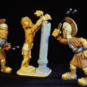 Drei stilisierte Tonfiguren – Jesus zwischen zwei römischen Soldaten.