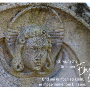Ein friedlicher Engelsrelief mit geschlossenen Augen und stilisierten Flügeln.