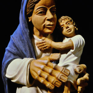 Eine detaillierte Tonstatue zeigt Maria mit Jesuskind, liebevoll und wertvoll dargestellt.
