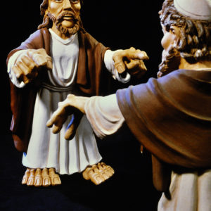 Zwei detailreiche Figuren, Jesus und ein Mann, begegnen sich vor schwarzem Hintergrund.