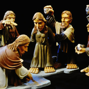 Eine Skulpturengruppe zeigt Jesus beim schreiben in den Sand . Expressive, detailreiche Figuren.
