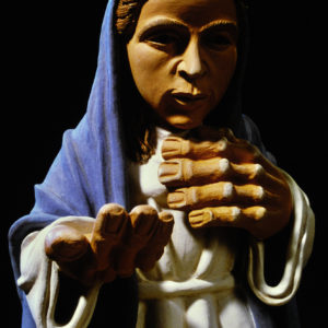Eine religiöse Skulptur, vermutlich Maria, zeigt andächtige Gebetshaltung vor schwarzem Hintergrund.