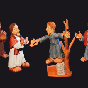Vier stilisierte Tonfiguren inszenieren eine biblische Szene vor schwarzem Hintergrund.