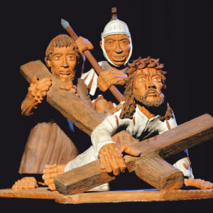 Die Tonskulptur zeigt die stilisierten, dramatischen Leiden Jesu am Kreuz mit Begleitern.