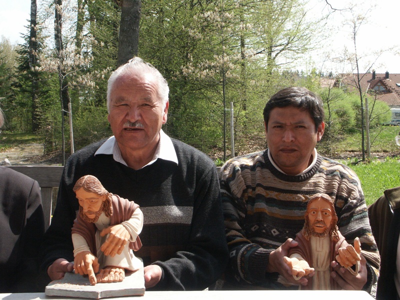Bild von Raul Castro und Sohn Fidel. Beide haben eine Tonfigur von Jesus in der der Hand