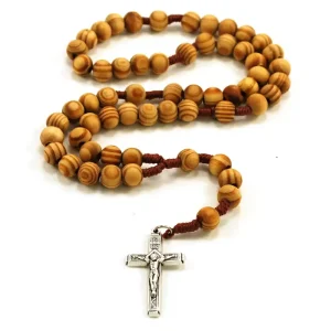 Ein Rosenkranz aus Holzperlen mit silbernem Kreuz liegt auf weißem Hintergrund.